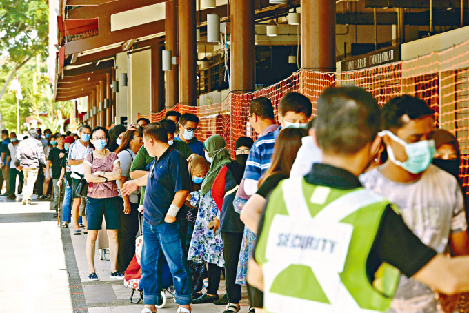 新加坡一市集上周有大批民眾排隊等候買雜貨。