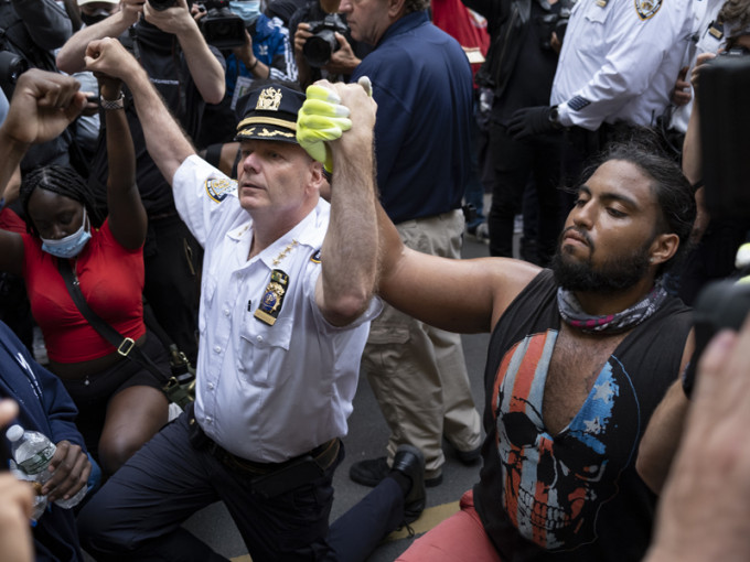 紐約警察局長與示威者握手下跪。AP
