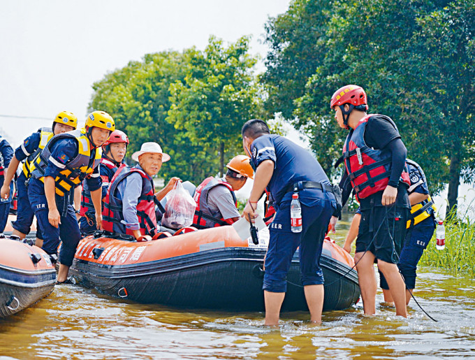 江西九江救援人员用橡皮艇疏散灾民。
