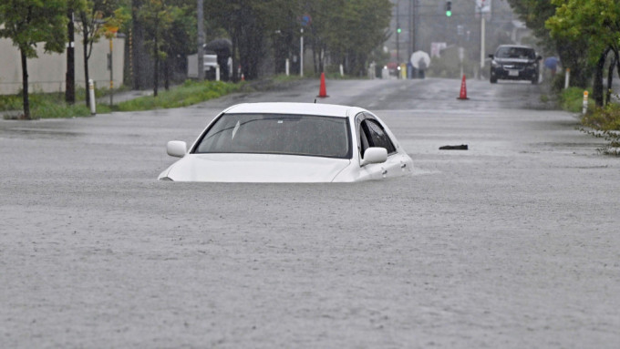 秋田市道路水浸一輛汽車駛過幾乎被淹沒。美聯社