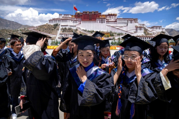 中国大学教育普及。图为西藏大学的毕业生准备拍毕业照。(AP图片)