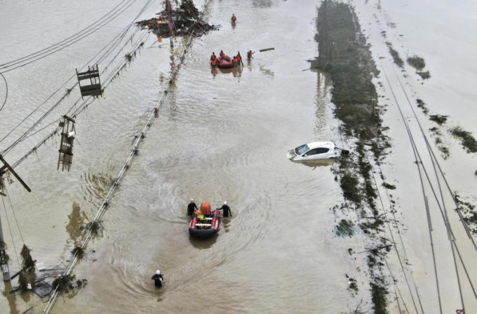 連續暴雨令九州多處氾濫，拯救隊人員需要出動橡皮艇救助受困市民。AP