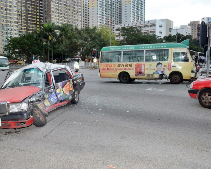 的士車身嚴重毀爛。右為涉案小巴。