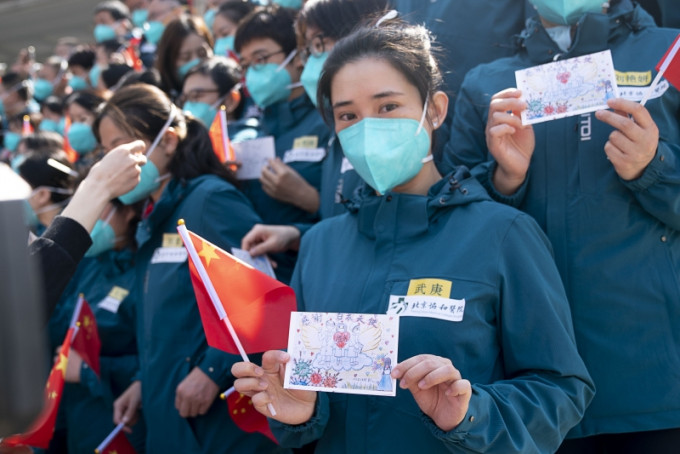 北京協和醫院國家援鄂抗疫醫療隊隊員展示市民送給他們的明信片。(新華社圖片)