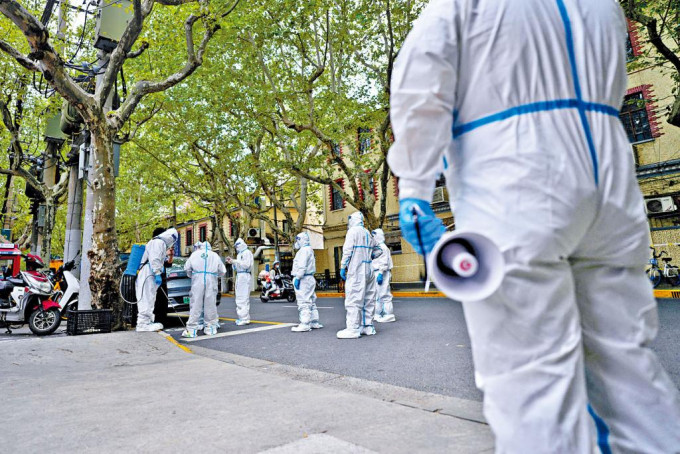 工作人员在封控下的上海街头进行消毒作业。
