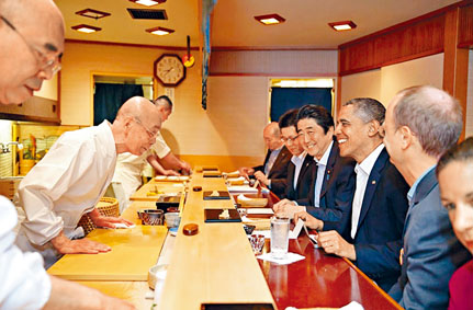 小野二郎（左）二〇一四年在店內接待奧巴馬和安倍晉三。