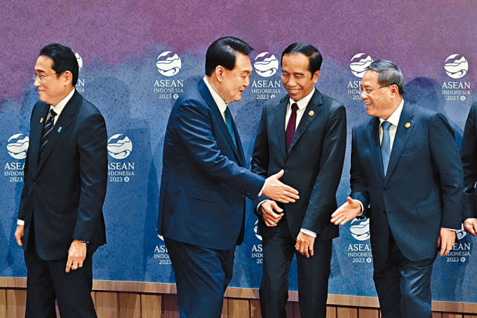 李强（右一）昨日与南韩总统尹锡悦握手。左一为日本首相岸田文雄。