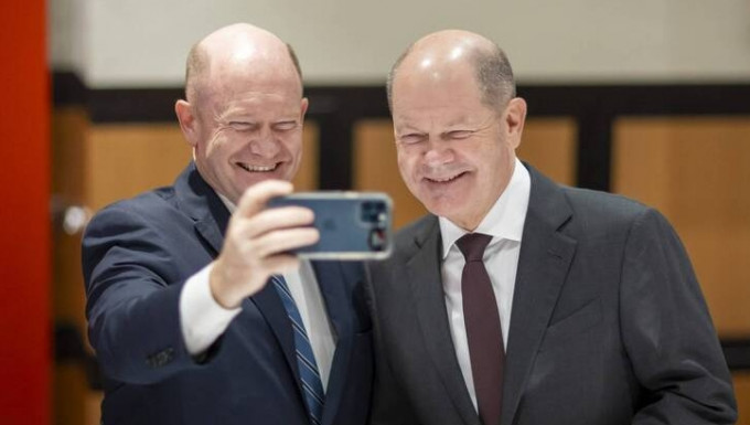 美国参议员昆斯（左）和到访的德国总理朔尔茨（右）自拍，两人样貌看起来一模一样。