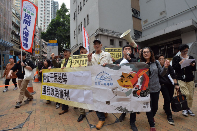 示威者手持寫有「停止干預選舉、還我政治權利」的橫額。