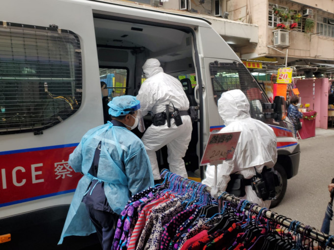 穿上保護袍，包括白色生化保護袍的警員今早到花園街198號調查走失確診病人。