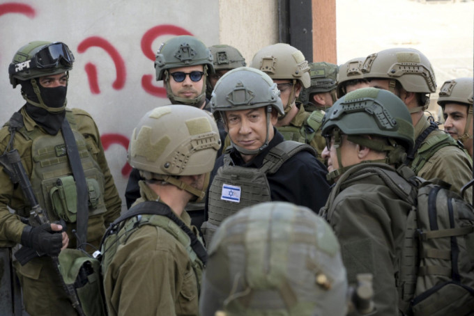 内塔尼亚胡（中）戴著头盔穿著避弹衣到访加沙。美联社