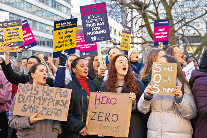 伦敦圣托马斯医院外，昨日有罢工护士举起标语牌要求加薪。
