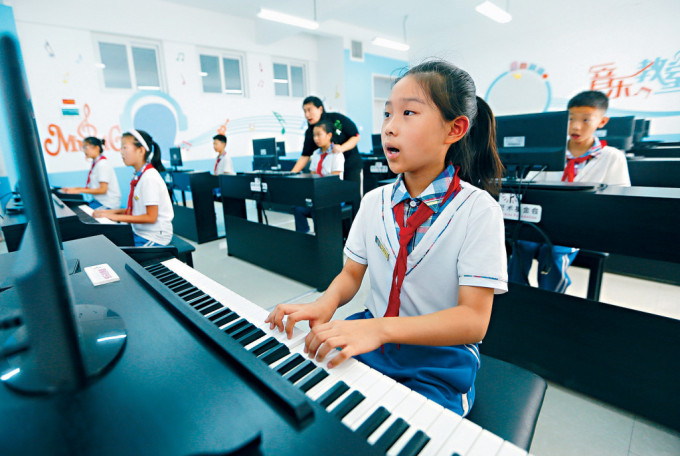 钢琴业走下坡，学琴人数锐减。图为山东小学生们在学习弹钢琴。
