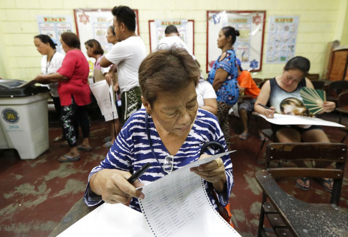 菲律宾马尼拉选民查看选票。AP图片