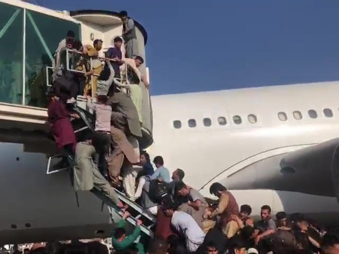 阿富汗大批民众试图强行登机逃离该国。影片截图