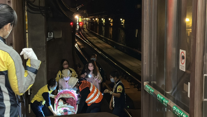 大批乘客摸黑由路軌行路返回月台。