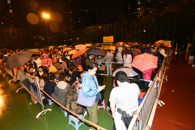 红磡观音庙晚上有逾千人撑著两伞冒著寒风排队等候。徐裕民摄