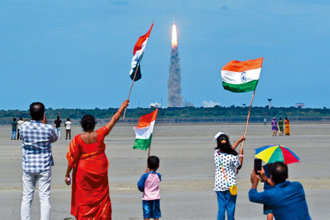 载有印度「月船3号」探测器的火箭，周五从安德拉邦小岛发射升空，民众挥舞国旗欢呼。　