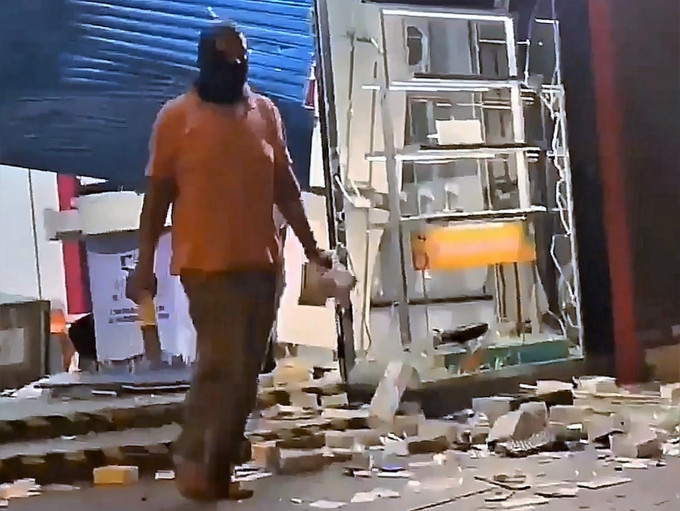 有南亞裔人士趁火打劫，掠去電訊商店內的手機。網圖