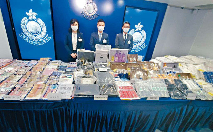 ■灣仔警區總督察何兆東（中），展示在淫窟搜獲的大批證物。