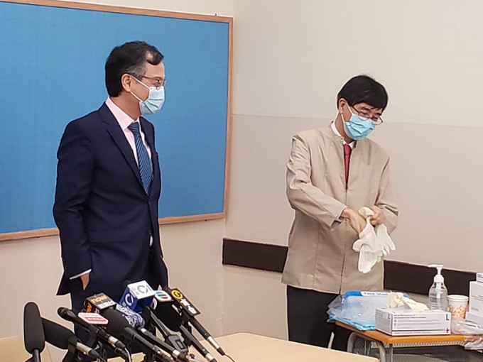 袁國勇(右)及林正財(左)下午到皇仁書院的檢測中心親身示範拭子採樣和深喉唾液採樣。