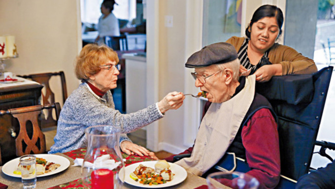 一名妇人在加州的护老中心，协助喂食患了阿兹海默症的丈夫。资料图片
