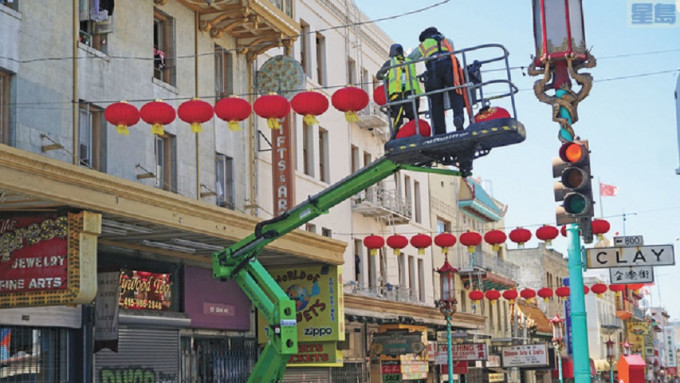 都板街上更换全新的大红灯笼，希望能为华埠经济重启带来好运气。记者黄伟江摄