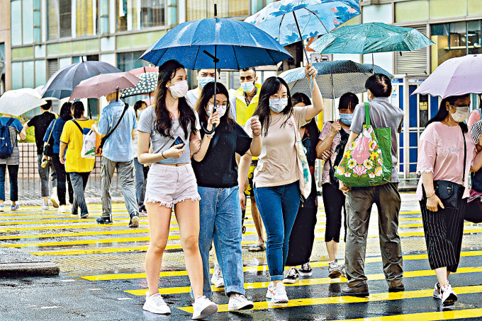 ■油麻地街頭途人，雨中仍不忘遵守口罩令。