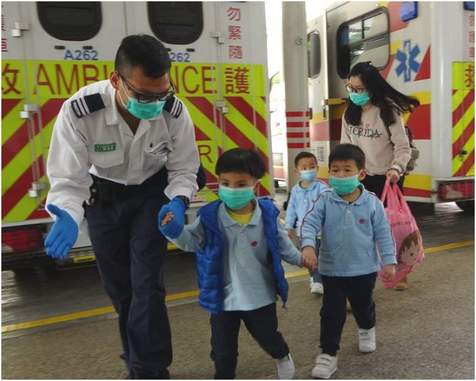 不适学童由老师陪同下送院检查。梁国峰摄