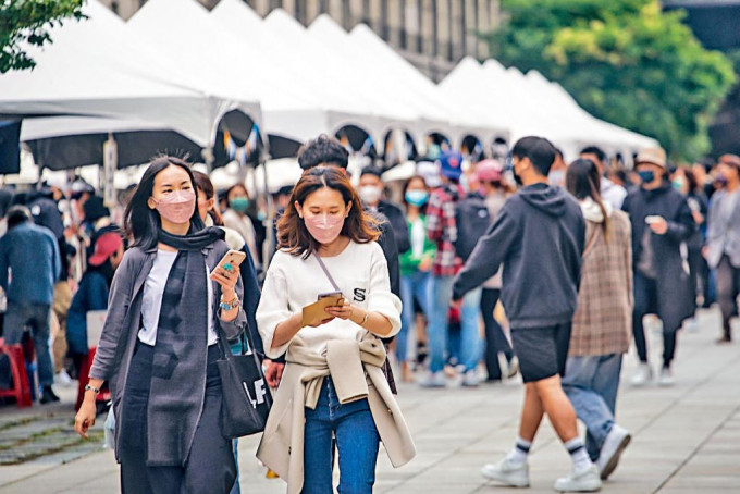 台北疫情升温，民众在人潮聚集的区域戴好口罩。