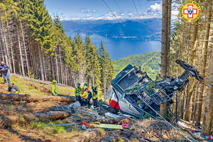 意大利斯特雷薩鎮一輛登山纜車周日墜毀，救援人員在車廂殘骸現場搜救。