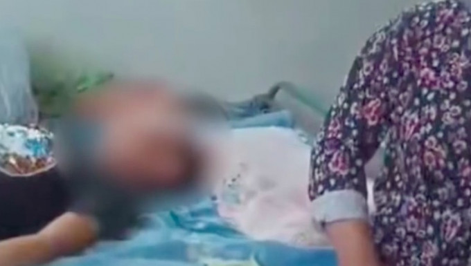 網傳影片中，一名男孩躺著沒了生氣，一旁疑似男孩的祖母泣不成聲。