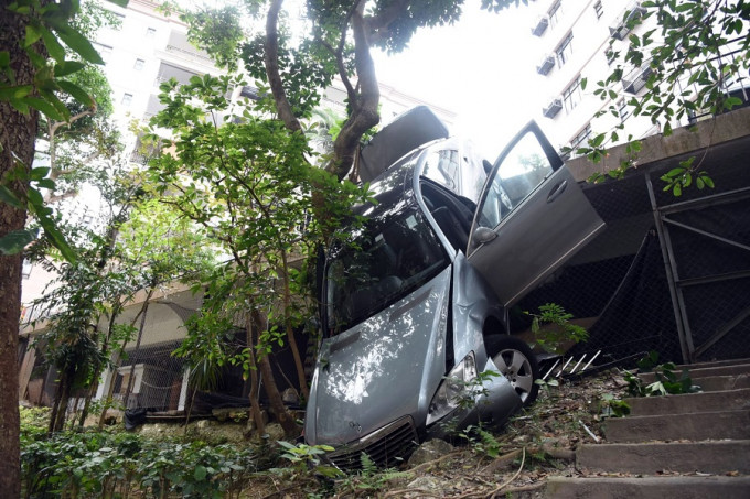 房车冲落山坡后，车头严重损毁，车尾则搁于平台上。