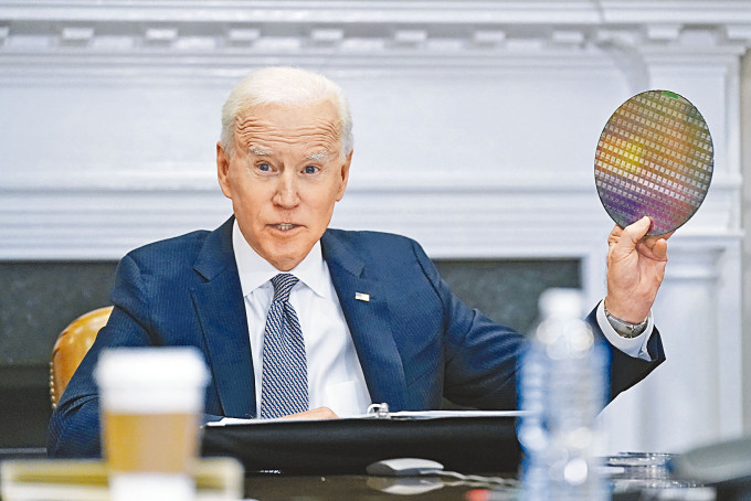 拜登四月在白宫参加半导体公司行政总裁视像峰会，手持一块晶圆。　