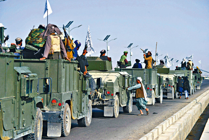 塔利班戰士周三在坎大哈坐上悍馬車，準備勝利巡遊。