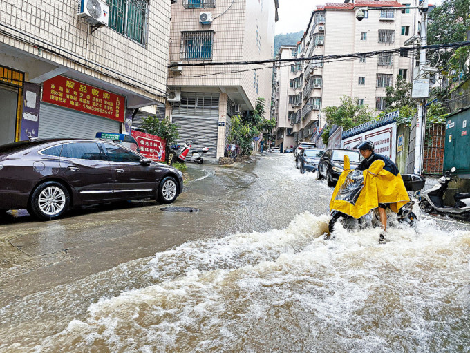 「海葵」过境后，福建宁德市民骑电动车涉水行车。
