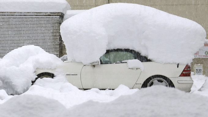  日本北部暴雪，有車輛被重重的積雪壓著。 AP