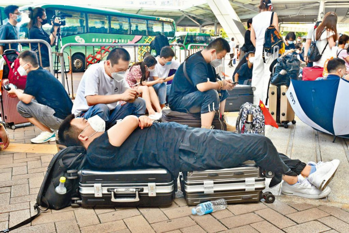 深圳湾口岸连日过关者众，有旅客用两个大箧作牀小睡片刻。