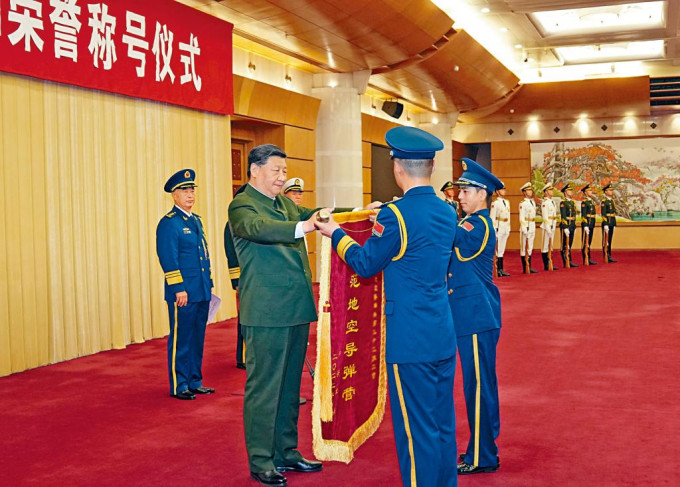 中央軍委在北京舉行頒授「八一勳章」和榮譽稱號儀式，習近平向獲榮譽稱號的單位頒授榮譽獎旗。