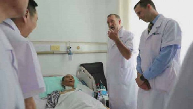 病床上的劉曉波骨瘦嶙峋，兩名外國專家正在其床邊為他會診。