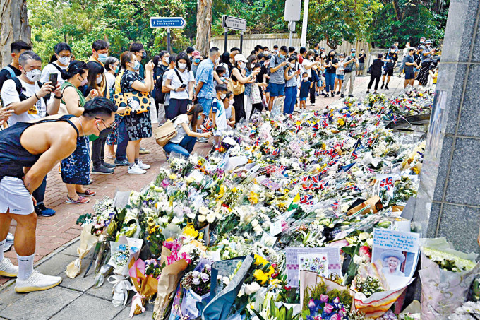 英國駐港總領事館外放有不少花束，也有英女皇的照片及悼念字句。