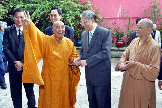 釋智慧要封山，時任房屋及規劃地政局局長孫公孫明揚到寶蓮寺會面，釋智慧之後擺出勝利手勢。資料圖片