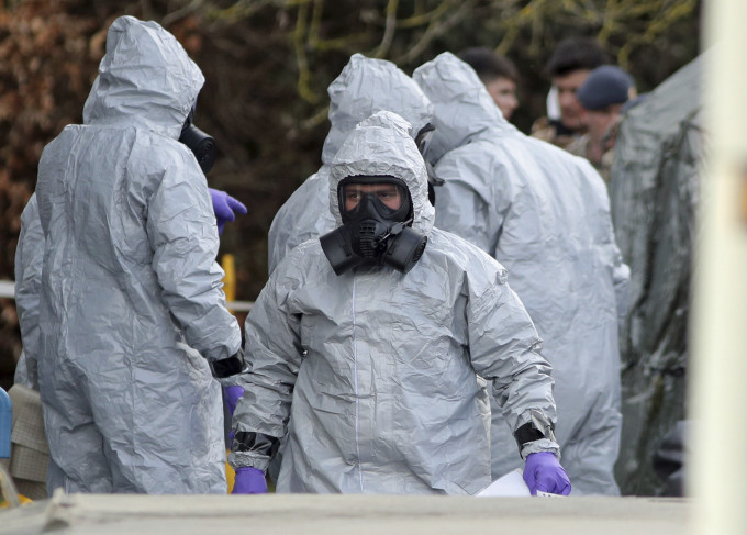 调查人员身穿保护衣物以免沾染神经毒剂。AP图片