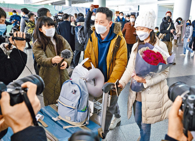 通关后首架由香港飞往北京的CX334航机昨顺利抵埗后，一位年轻人在抵达出口迎接自己的女友。