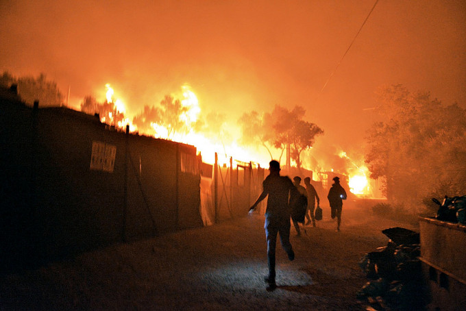 莫里亞難民營內的人逃離火場。