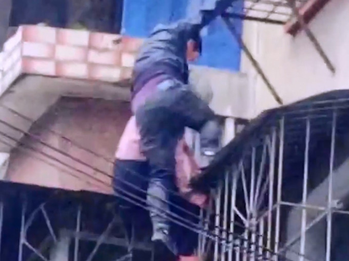 福建修車工人爬上簷蓬，將老婦帶離險境。影片截圖