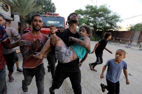 加沙北部賈巴利亞難民營上周遭空襲後，巴勒斯坦人從被毀建築物廢墟下救出受傷女童。美聯社