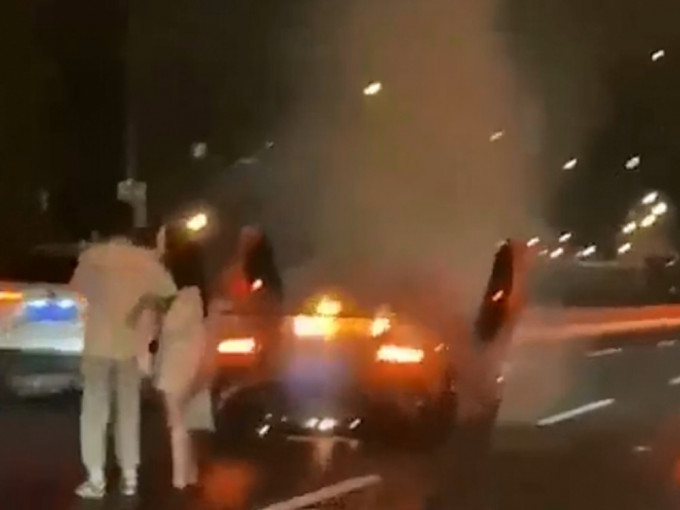 上海男子林宝坚尼座起火，但他只顾安慰女友，淡然看座驾焚毁。影片截图