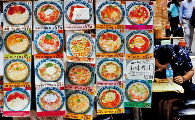 东京阿美横丁商业区一间餐厅外展示的美食图片。