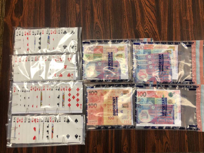 警方捡获一批证物，包括一副扑克牌及小量赌款。警方提供图片